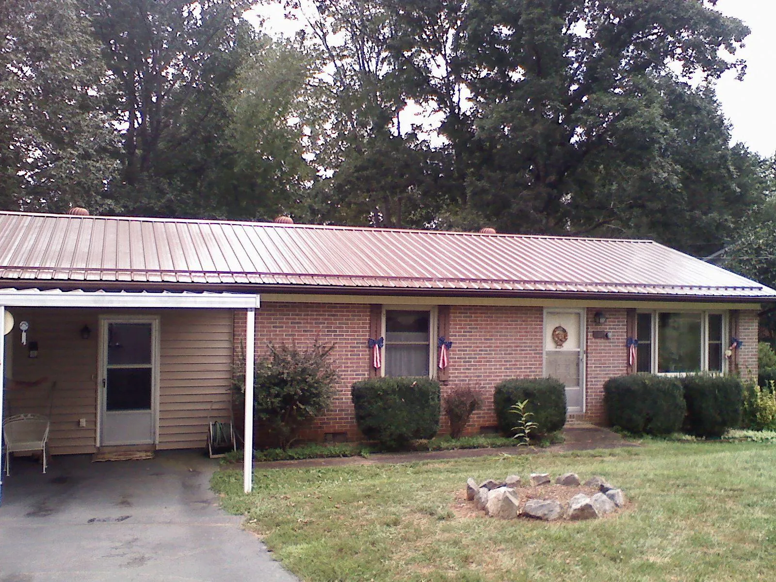 Bronze metal roof and carport on a brick ranch home — Roof Repair work by our crew in Holmes